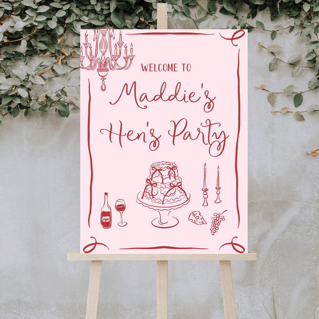 Welcome guests to "Maddie's Hen's Party" with a personalised pink acrylic sign from Etched Design. This elegant Hen's Party Welcome Sign features illustrations of a chandelier, cake, wine bottle, two glasses, grapes, and two candlesticks. The charming design is framed with decorative swirls against a backdrop of green foliage and displayed on an easel for added sophistication.