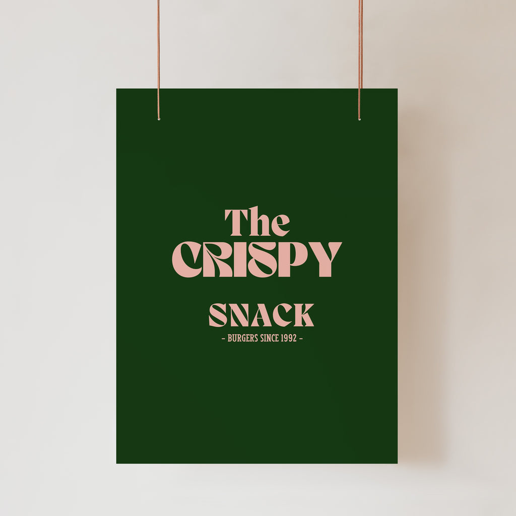 An Etched Design UV Printed Business Sign in dark green acrylic with beige text hangs against a white background. The custom logo printing reads, "The Crispy Snack - Burgers since 1992 -" in bold, stylized font.